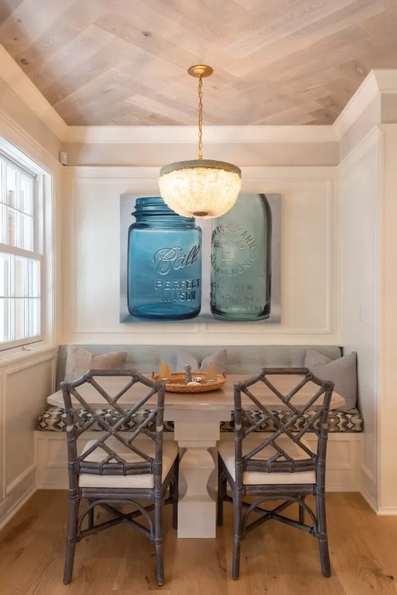 Breakfast nook banquette with interior windows onto the three-season porch