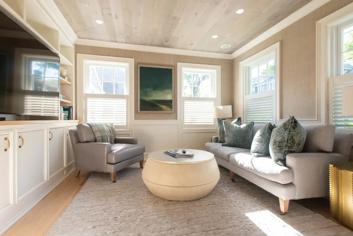 Sunny den with built-in cabinetry, a custom ceiling treatment and oversized glass doors