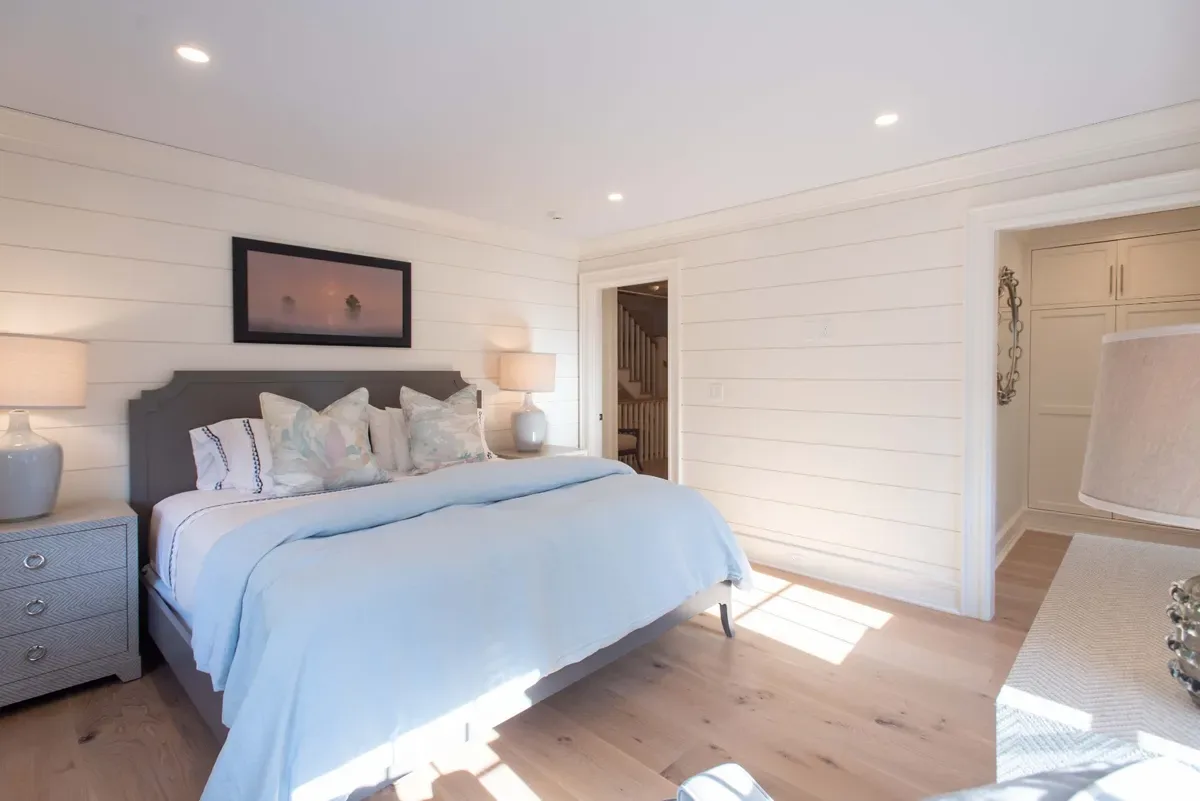 West guest suite with a king bed and shiplap wall